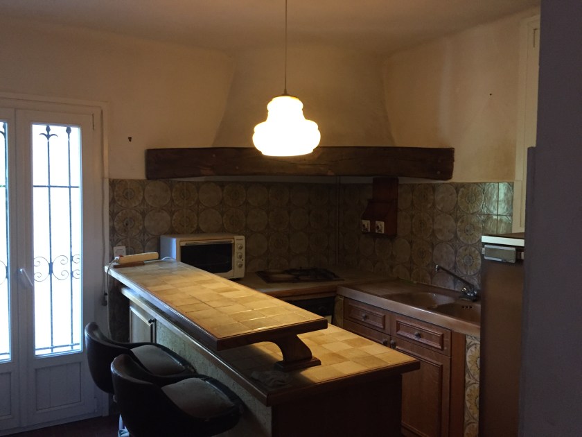 Seventies style kitchen with brown tiles and a huge corner chimney